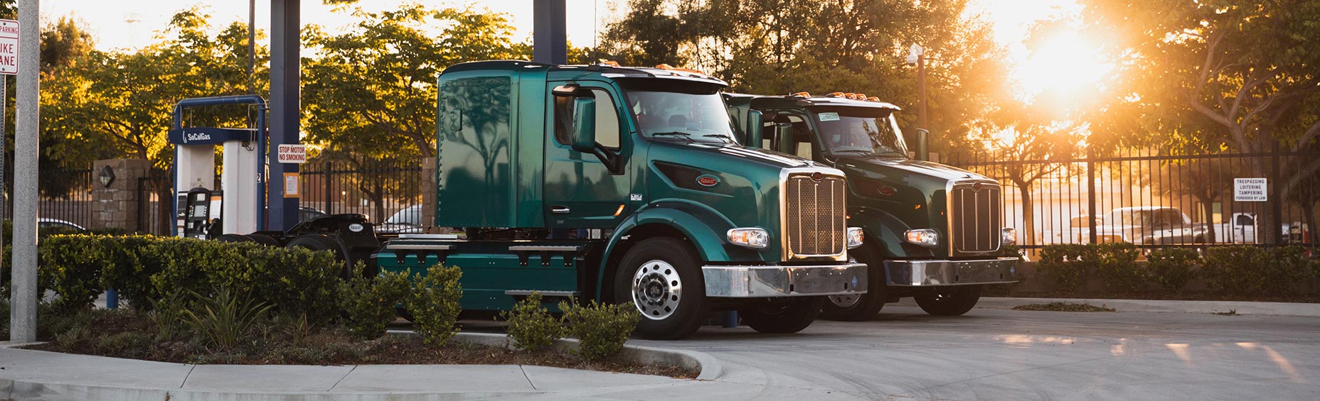 two semi-trucks next to compressed natural gas station