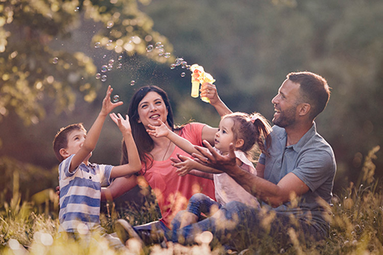 family outdoors playing with bubbles