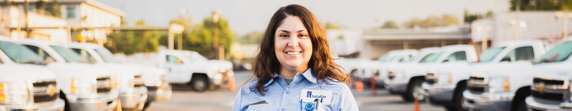 woman, SoCalGas employee, trucks in background