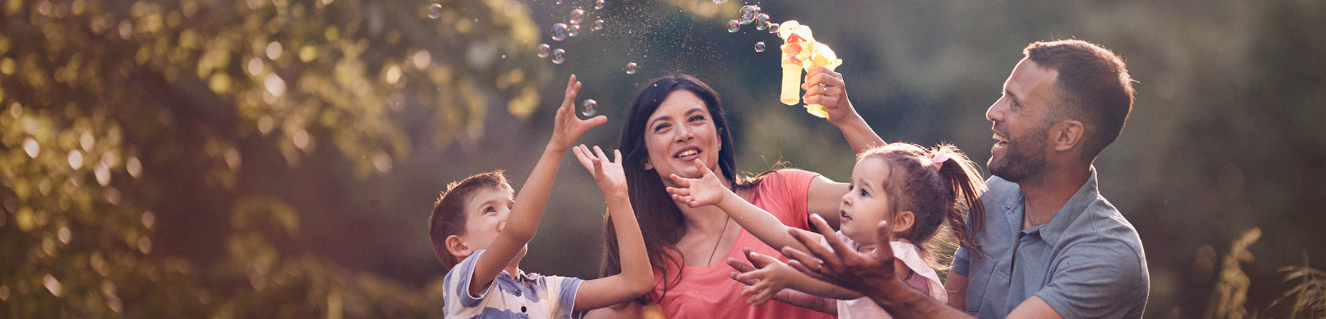 family outdoors playing with bubbles