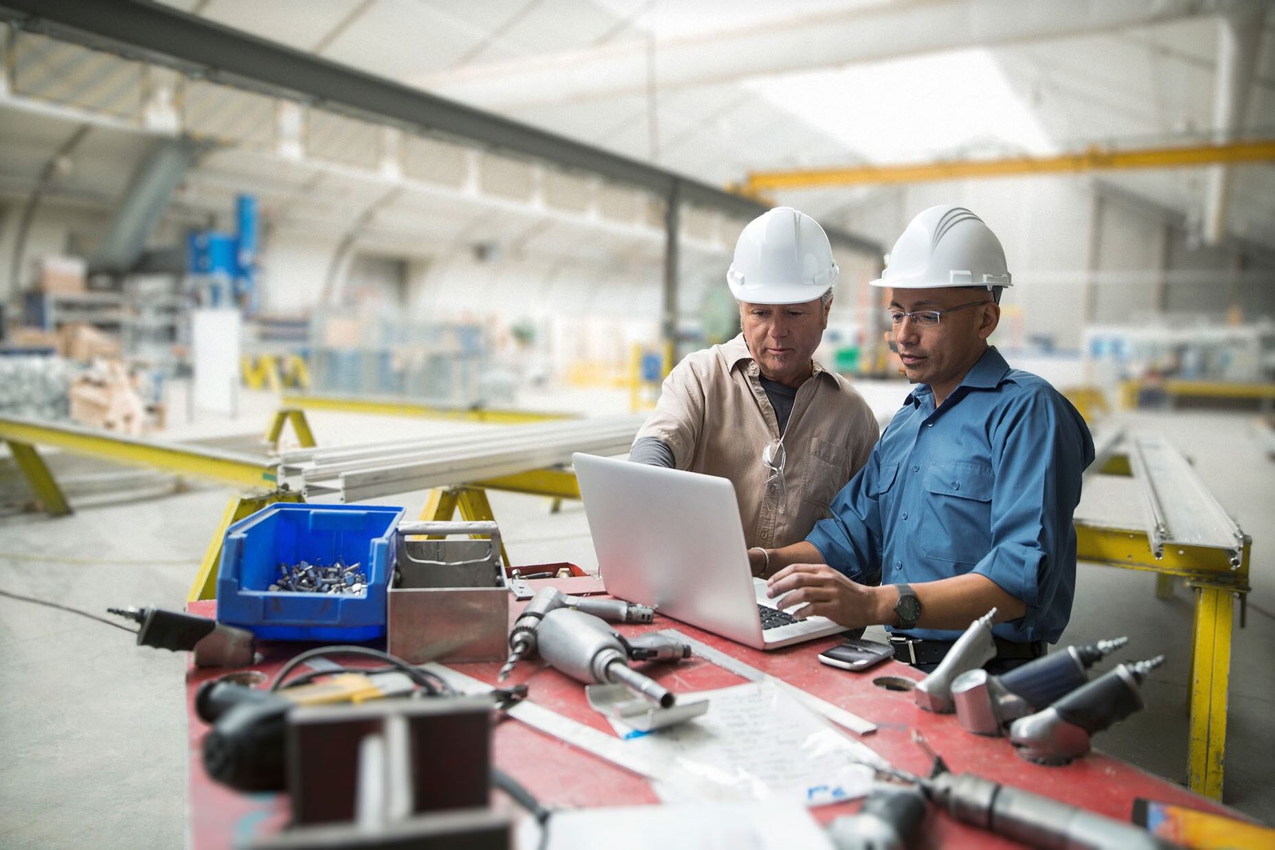 Two people wearing hard hats in a warehouse