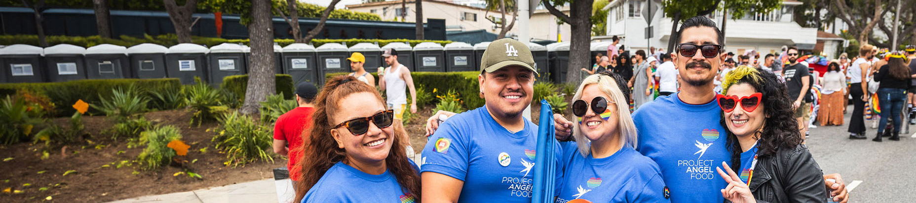 people smiling with blue shirts and rainbow flags