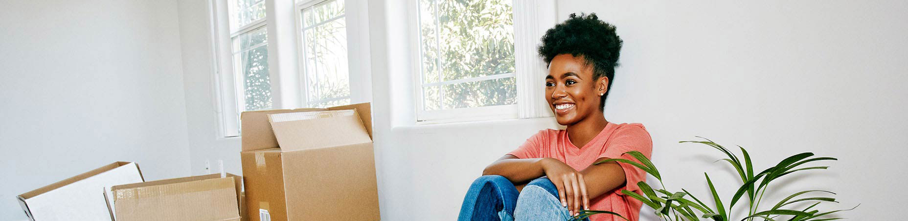 woman sitting in room with moving boxes