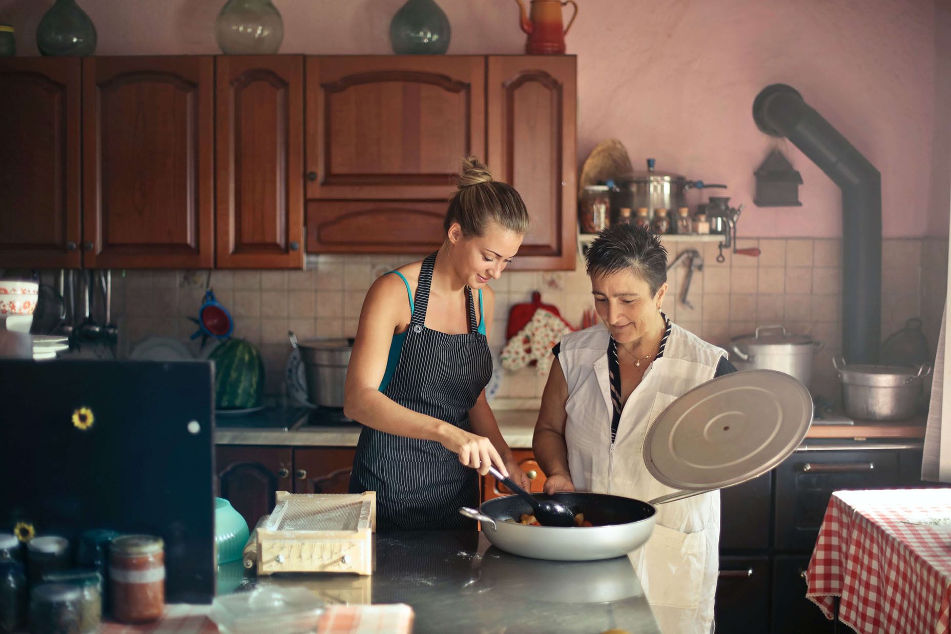 two women in kitchen stirring pot