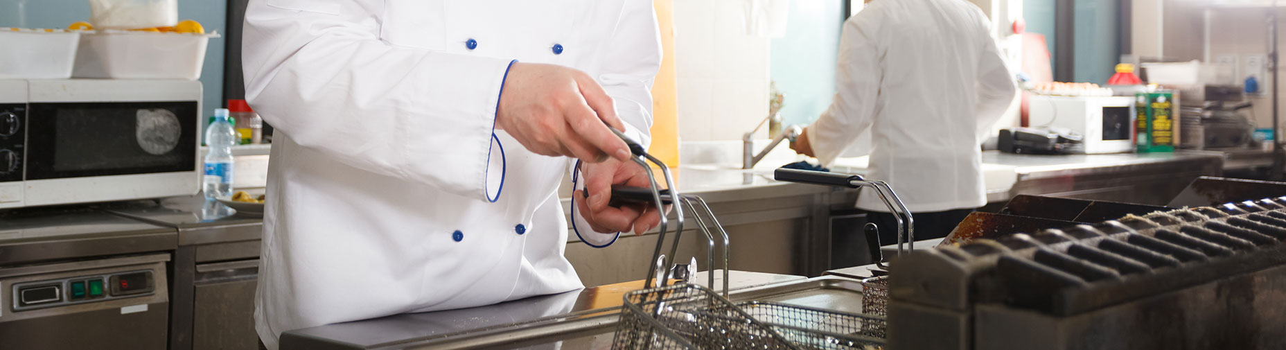 chef using fryer in kitchen