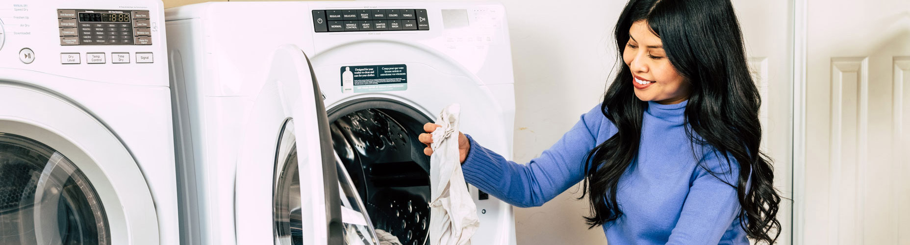 woman placing clothes in laundry basket