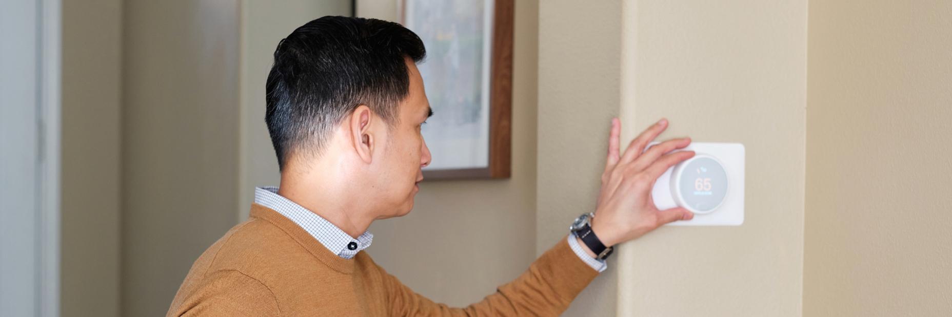 Man adjusting thermostat