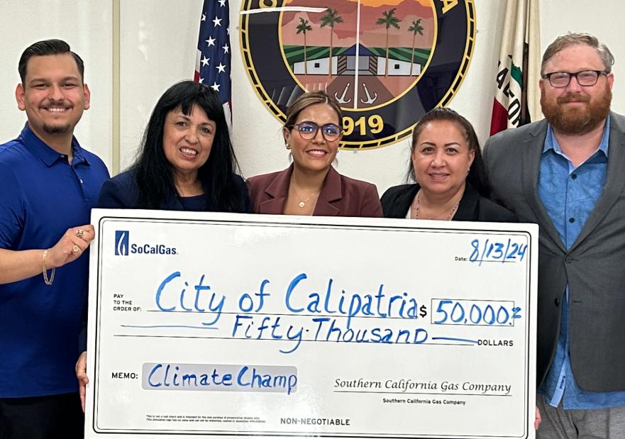 People holding a large check for a climate resiliency grant