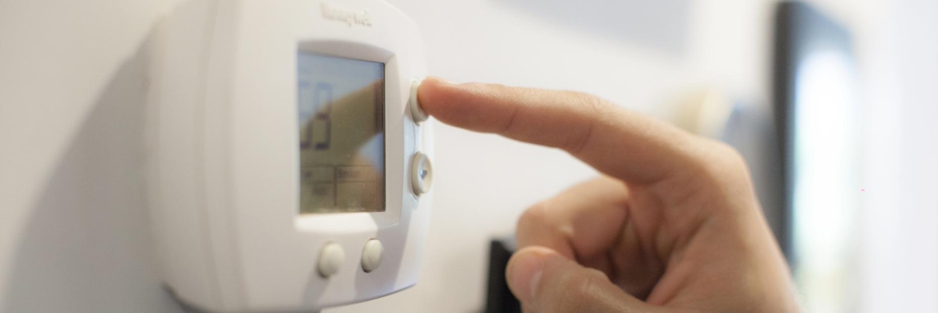 Person adjusting thermostat