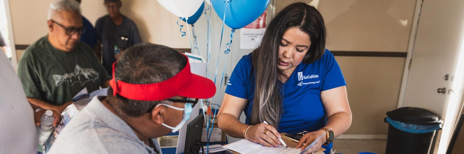 SoCalGas employee helping resident with paperwork